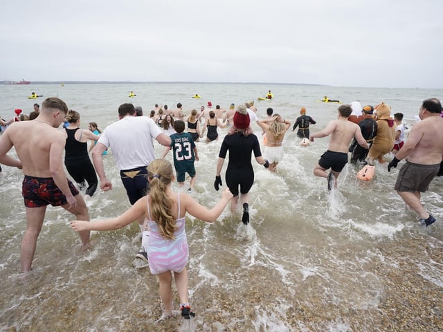 People run into the sea as they take part in the Gosport New Year's Day Dip in The Solent at Stokes Bay, Gosport, Hampshire, to raise money for Gosport and Fareham Inshore Rescue Service.