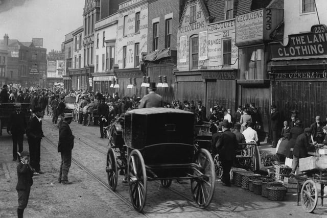 1892:  A carriage travelling past a street market at Southsea.  (Photo by F J Mortimer/Hulton Archive/Getty Images)