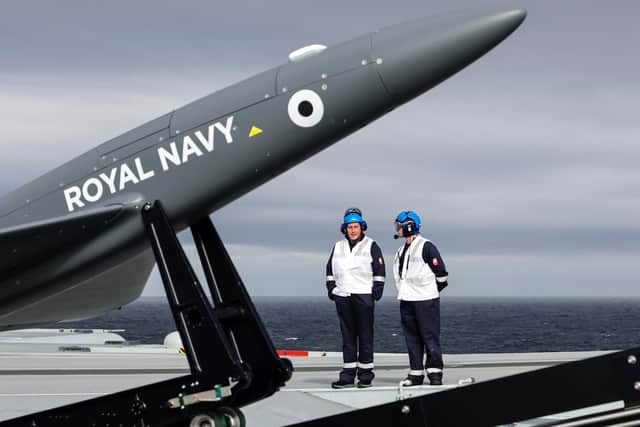 Sailors watch over the Banshee drone after it was set up on its launch platform on HMS Prince of Wales. Photo: LPhot Ben Corbett