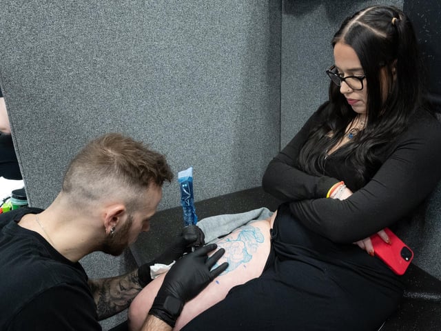 Pictured is: Lilly Burkett has her tattoo worked by Dan Pease
Picture: Keith Woodland (010421-22)