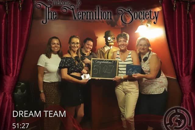 A team celebrating completing a room at Other World Escapes.