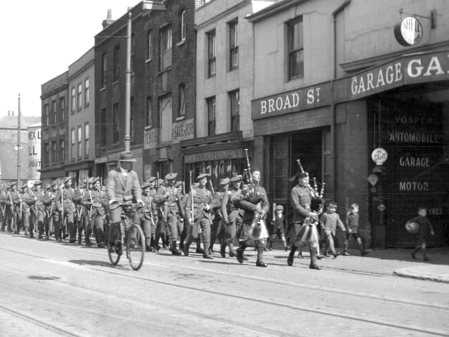 A Scottish regiment march along Broad Street, Old Portsmouth. Seen marching ‘at ease’ can be seen soldiers of a Scottish regiment. Year unknown