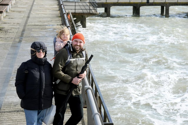 Despite the wind many people enjoyed the sunshine in Old Portsmouth on Good Friday. Pictured is: Rhian Woodward her partner Richard De Luca and their daughter Ffion (2) from Oxford.Picture: Sarah Standing (290324-6967)
