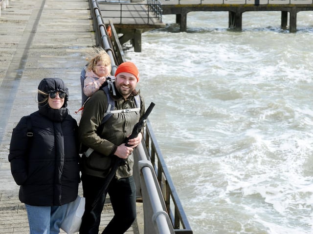 Despite the wind many people enjoyed the sunshine in Old Portsmouth on Good Friday. Pictured is: Rhian Woodward her partner Richard De Luca and their daughter Ffion (2) from Oxford.Picture: Sarah Standing (290324-6967)