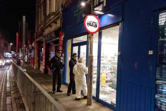Police and a forensic officer at Lalys Pharmacy on Wednesday night
