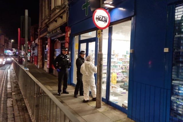 Police and a forensic officer at Lalys Pharmacy on Wednesday night