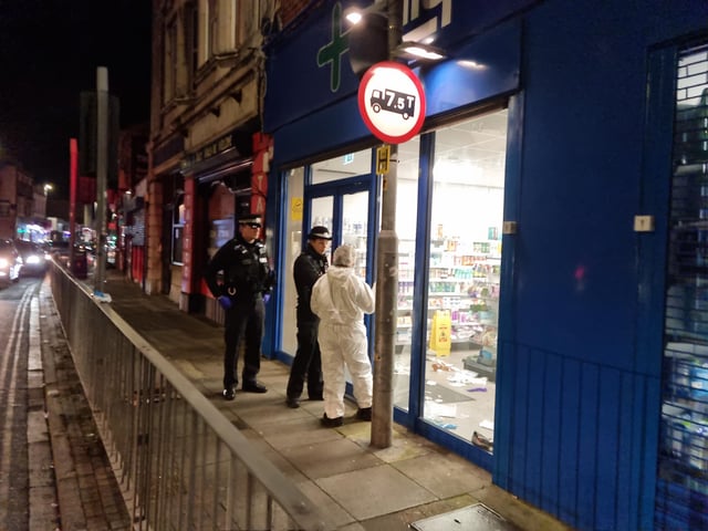 Police and a forensic officer at Lalys Pharmacy on Wednesday night