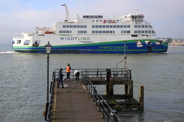 A Wightlink ferry passes fishermen on December 31, 2020 in Portsmouth, England. Photo by Finnbarr Webster/Getty Images