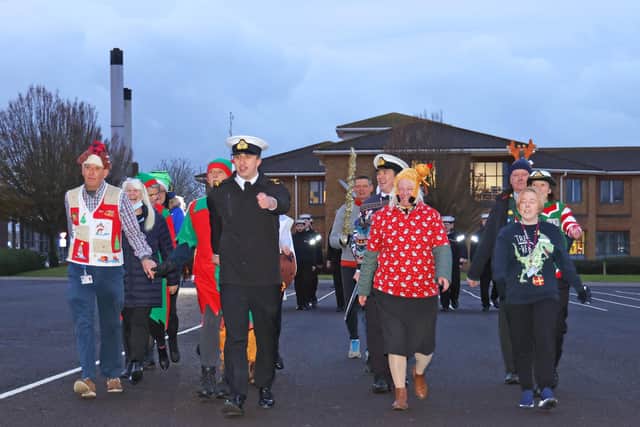 Sailors wearing festive jumpers take part in a charity divisions event on HMS Sultan's parade square