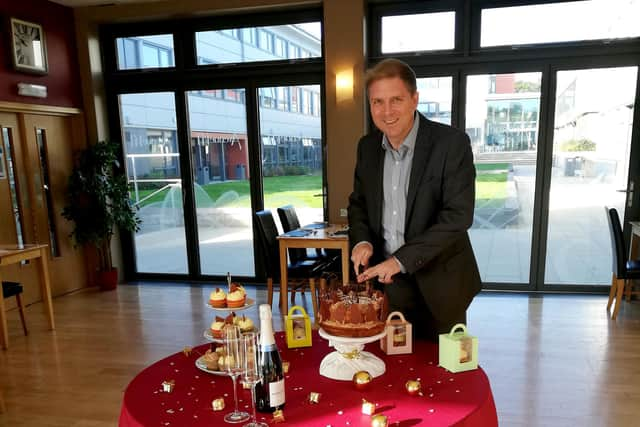 Fareham College principal, Andrew Kaye, cutting a cake to celebrate the college's fiftieth birthday.