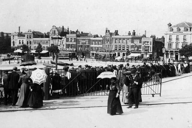 Crowds of spectators look down on Mudlarkers scrabbling for coins in the silt off The Hard at Portsea more than a century ago.