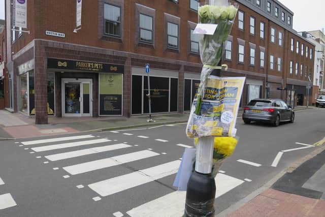 Flowers and a police sign appealing for witnesses have been put in Cosham high street near Vectis Way, where an 85-year-old woman died in a van crash on October 7 2021. Picture: Ben Fishwick