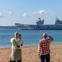 Onlookers at Southsea Beach watching HMS Prince Of Wales being deployed. Picture: Mike Cooter (280924)