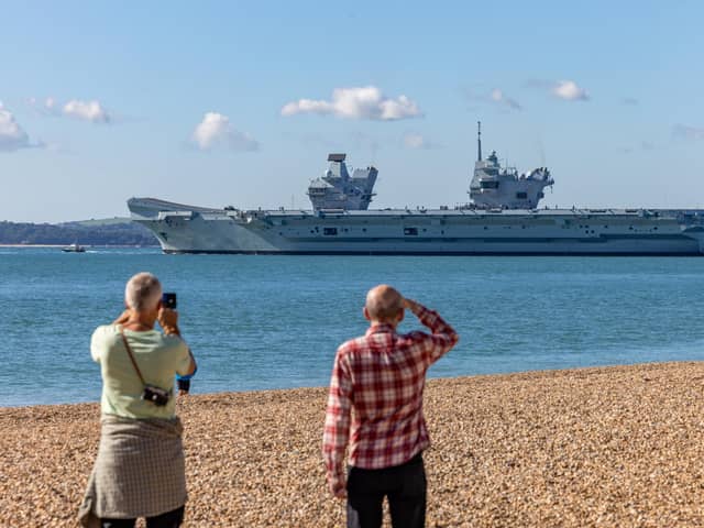Onlookers at Southsea Beach watching HMS Prince Of Wales being deployed. Picture: Mike Cooter (280924)