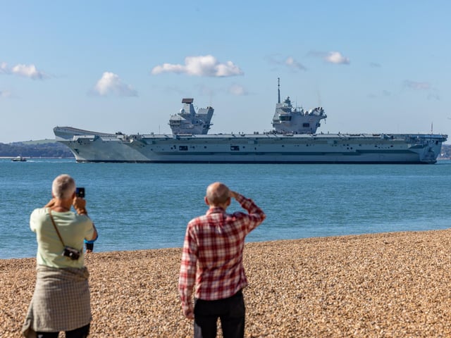 Onlookers at Southsea Beach watching HMS Prince Of Wales being deployed. Picture: Mike Cooter (280924)