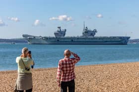 Onlookers at Southsea Beach watching HMS Prince Of Wales being deployed. Picture: Mike Cooter (280924)