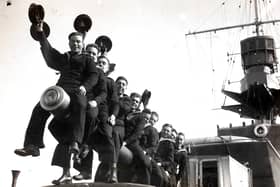 A group of RNVR (Royal Naval Volunteer Reserve) ratings raise a cheer on reaching Plymouth, England on the 'HMS Curacoa'. Officers and ratings of the RNVR (London and Sussex Divisions) are spending Easter afloat - they left Portsmouth for Plymouth and Torbay and are carrying out practical training including gunnery during their cruise. (Photo by Fox Photos/Hulton Archive/Getty Images)