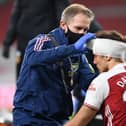 David Luiz of Arsenal receives treatment from physio Jordan Reece for a head injury during the Premier League match last November. Photo by David Price/Arsenal FC via Getty Images.