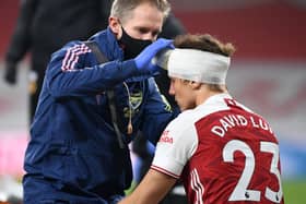 David Luiz of Arsenal receives treatment from physio Jordan Reece for a head injury during the Premier League match last November. Photo by David Price/Arsenal FC via Getty Images.