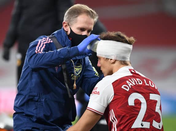 David Luiz of Arsenal receives treatment from physio Jordan Reece for a head injury during the Premier League match last November. Photo by David Price/Arsenal FC via Getty Images.