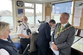 Councillor Hutchinson discusses the work of National Coastwatch with Watchkeepers Caroline Hildrew and Nick Carter, while his driver Mark studies one of the maritime charts.
