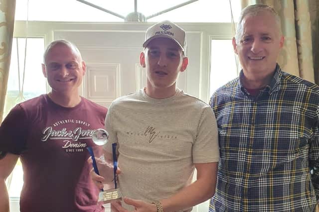 Ronan Curtis collects his prize from Pompey Northern Ireland Supporterts' club chairman Bob Woolley, right, and marketing manager James Attwood, left.