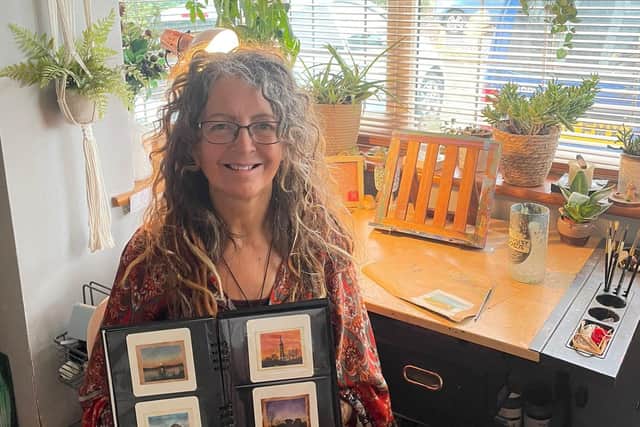Caroline West, 49, holding a collection of her artwork, which consists of painting famous UK landmarks on used teabags. Picture: Ella Sandy/family handout/PA Wire