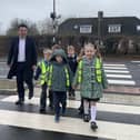Havant MP Alan Mak tries out a new crossing with children from Fairfield Infant School