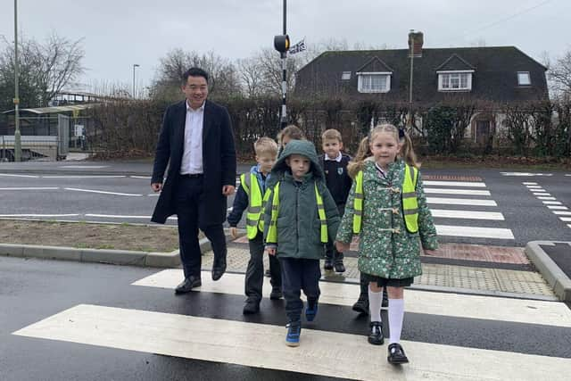 Havant MP Alan Mak tries out a new crossing with children from Fairfield Infant School