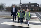 Havant MP Alan Mak tries out a new crossing with children from Fairfield Infant School