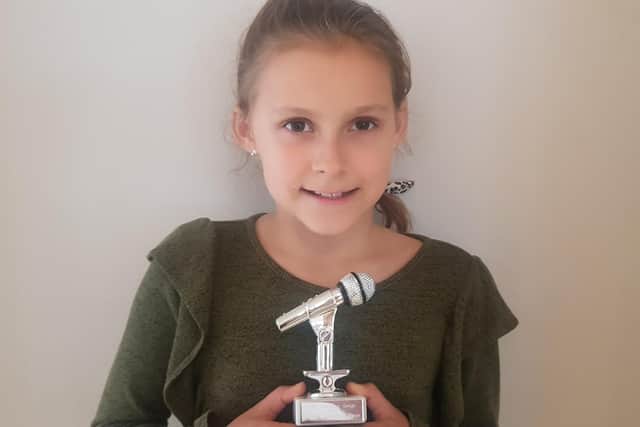 Keen performer Mia Lintott, 10 from Lovedean, has been singing a song every day for 100 days to cheer people up during lockdown. Pictured: Mia with her trophy given to her by entertainer Mark Harris, who has offered her a free recording session in his studio