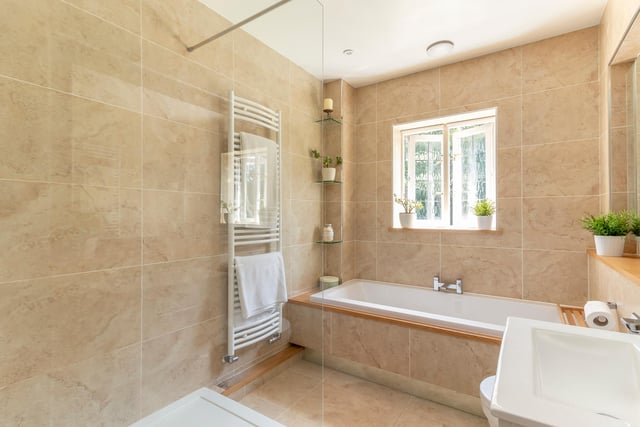 There are four bathrooms in total, including a luxurious en-suite to the main bedroom, two further bathrooms serving the remaining bedrooms, and a large shower room with marble tiling.