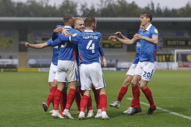 Jack Whatmough is mobbed by his team-mates after netting in Pompey's 4-2 success at Burton on Saturday. Picture: Daniel Chesterton/phcimages.com