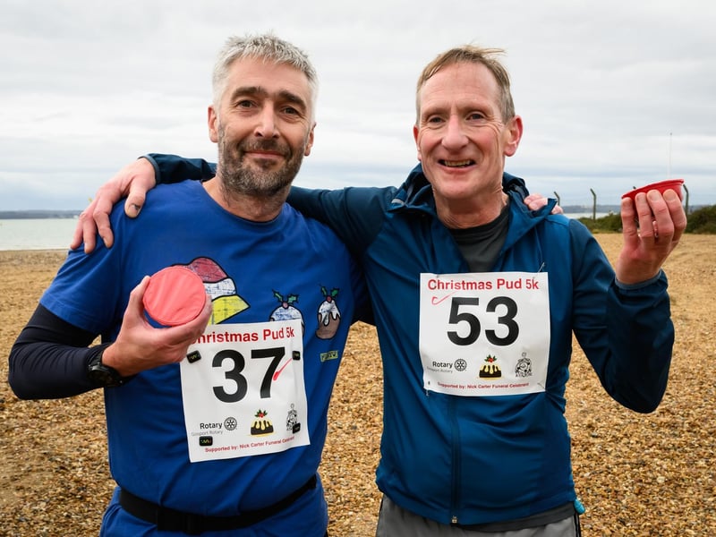 Each runner received a Christmas pudding at the finish line. Joe Duffin and Graham Cate celebrate with theirs at the Christmas Pud 5k, Stokes Bay, Gosport