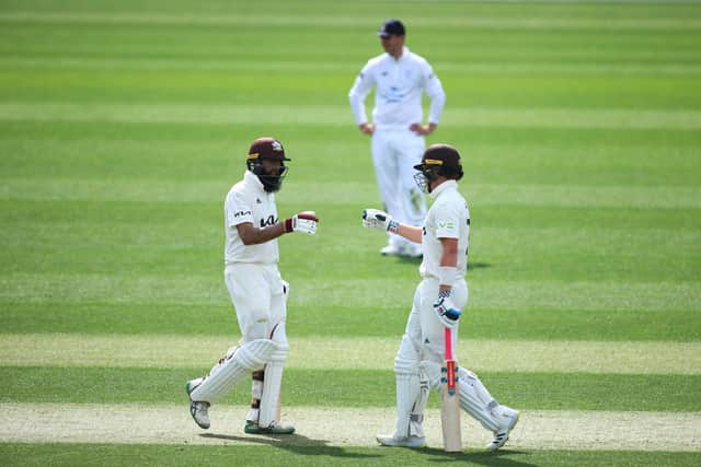 Ollie Pope and Hashim Amla of Surrey punch gloves during day one of the the LV= Insurance County Championship match against Hampshire. Photo by Jordan Mansfield/Getty Images.