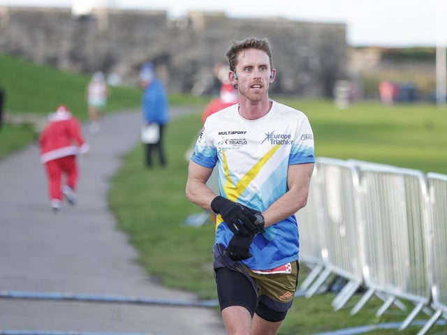 Conrad Young crosses the line to finish first in the half marathon. Picture: Chris Moorhouse (221224-66)