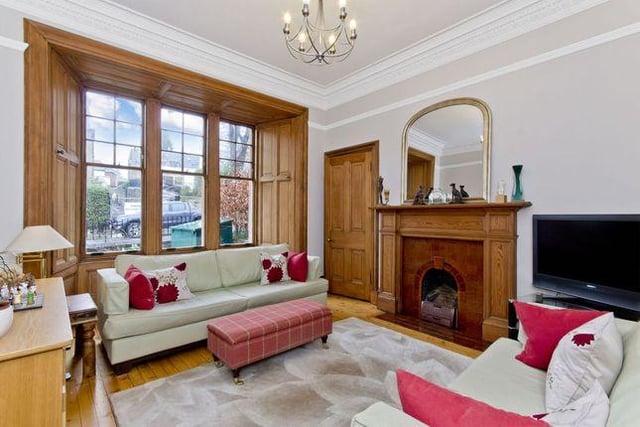 The living room lets in a lot of light and at the heart of the room is a feature fireplace, which is flanked by an Edinburgh press
