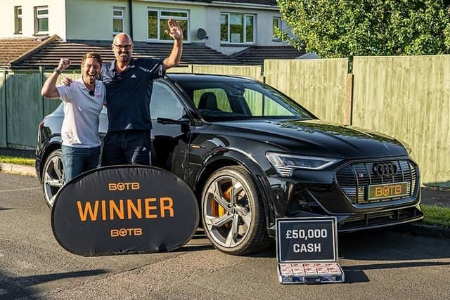 Waterlooville father Rik Dewane, 51, scooped a £125k prize from BOTB, including an Audi E-tron Sport 55 Quattro with £50k in cash in the boot. Pictured is BOTB presenter, Christian Williams, and Mr Dewane.