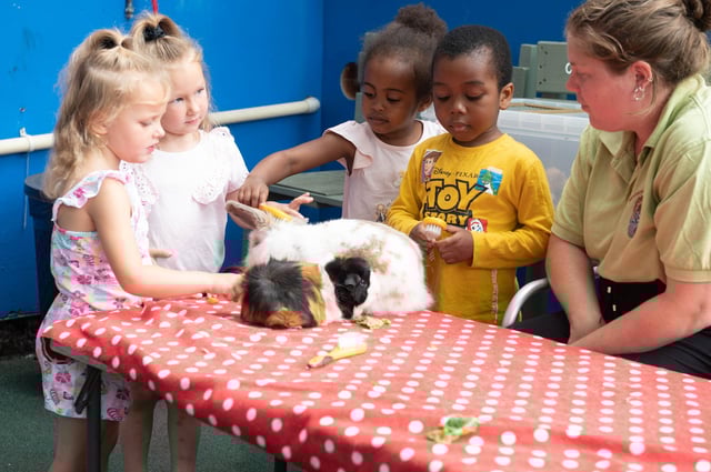 Victoria Hobin, who volunteers at the Mucky Bucket Farm, posing with the children at Roberts Centre nursery. Picture: Mable Nsingo