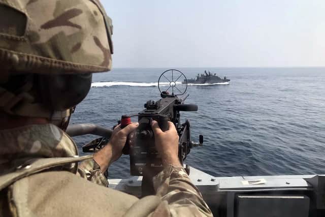 A sailor trains his weapon on the American patrol ship. Photo: Royal Navy