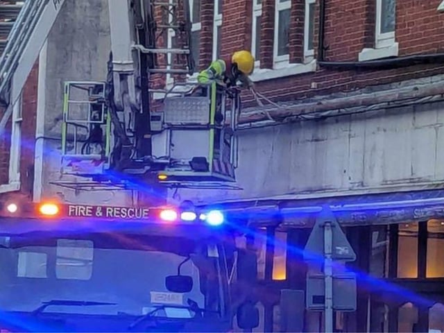 Firefighters fixing loose roof tiles and a sign above Poppins Cafe in North Street, Havant, on January 2.