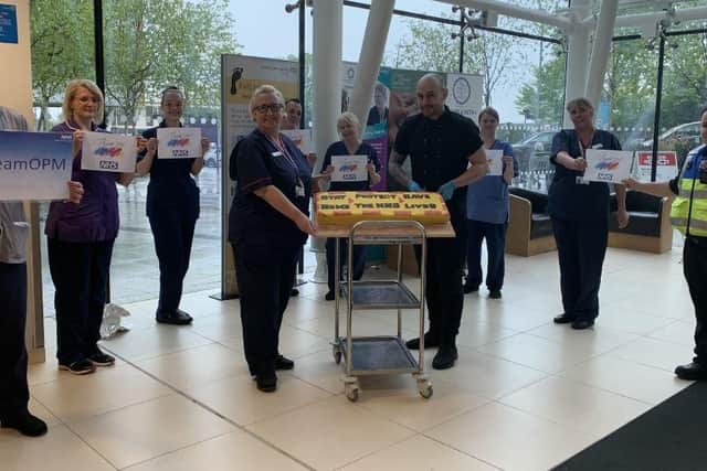 Chef, Jordan Thompson, presents his cake to QA matron, Marion Moffat.