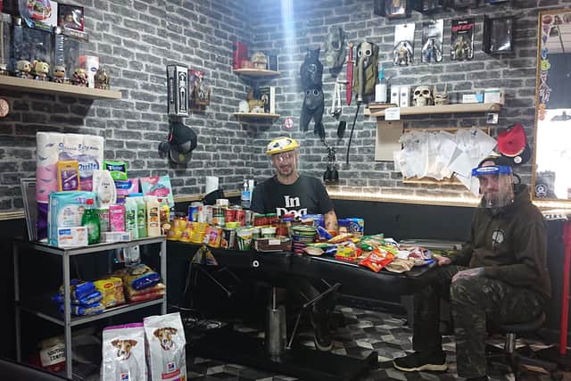 Gosport tattoo artist Steve Lowry is turning his studio into an independent food bank for people who need it during lockdown. Pictured: Steve with piercer Jay Twyford and some of the donations from clients