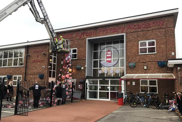 Crew from Southsea Fire Station helping assemble the poppy art installation at Ayrton Ark Academy