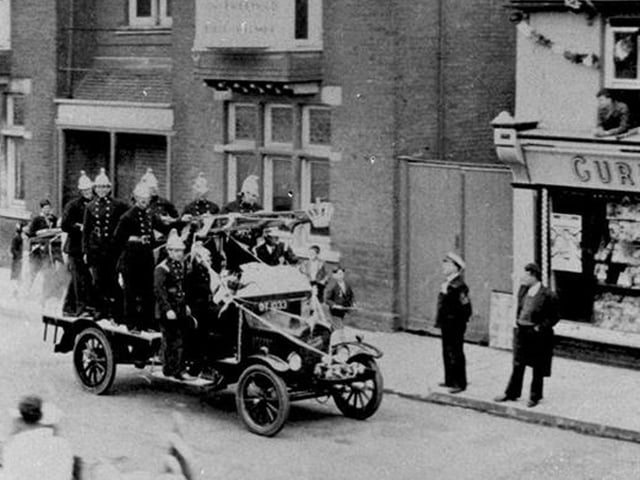 Waterlooville fire engine in a parade for the 1935 Silver Jubilee of George V, passing the Queen's Hotel. This fire engine is a Ford Biaco and was passed on from Havant Brigade when they received a new Fire engine in 1933.