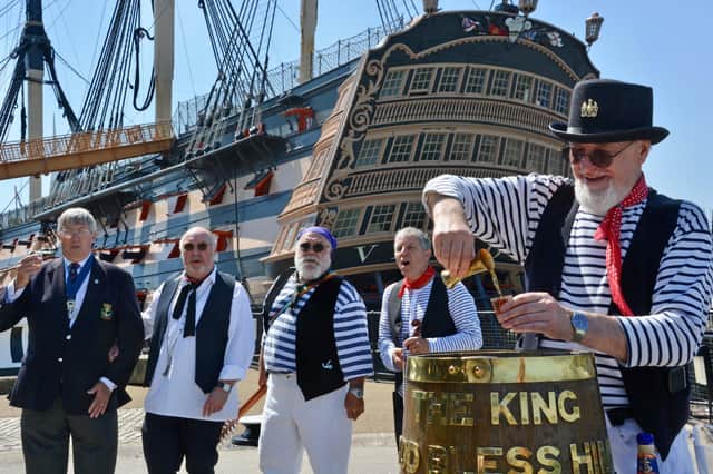 Keith Ridley, national chairman of the Royal Naval Association (left) toasts a tot of rum with the 'Andsome Cabin Boys sea shanty band at Portsmouth Historic Dockyard to mark the 50th anniversary of Black Tot Day - the day the Royal Navy stopped issuing sailors their daily rum ration . Photo: PA