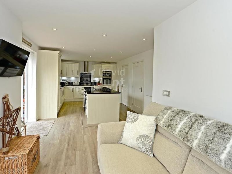 This shot shows the depth of the breakfast kitchen. It also features a built-in electric oven, separate five-ring gas hob with extractor, integrated fridge/freezer and dishwasher, and even a wine cooler.