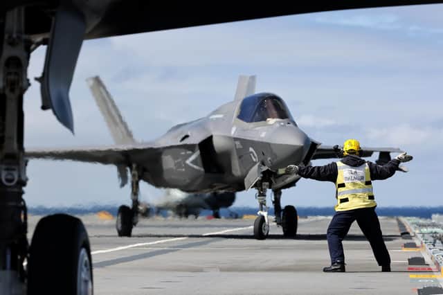 An aircraft handler pictured directing an F-35B Lighting jet into position on HMS Queen Elizabeth