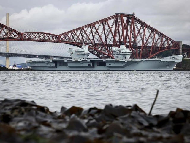 HMS Queen Elizabeth leaving Rosyth in Fife, Scotland, and sailing under the Forth bridge. She is due to return home to Portsmouth on July 30.