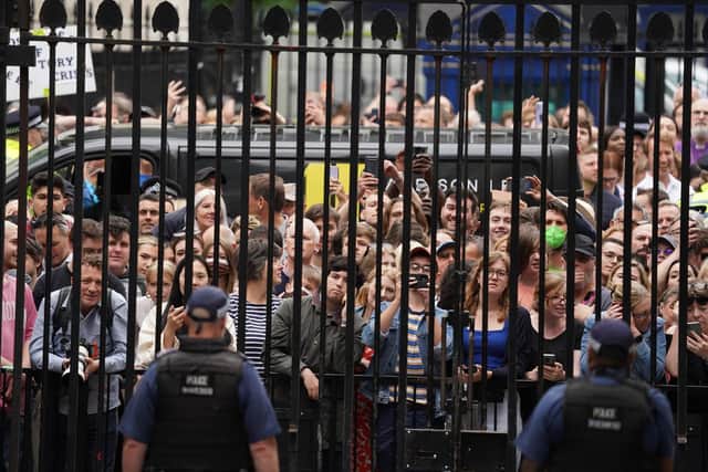 Members of the public stand outside the gates of Downing Street as Prime Minister Boris Johnson reads a statement outside 10 Downing Street, London, as he formally resigns as Conservative Party leader after ministers and MPs made clear his position was untenable. He will remain as Prime Minister until a successor is in place. Picture date: Thursday July 7, 2022.